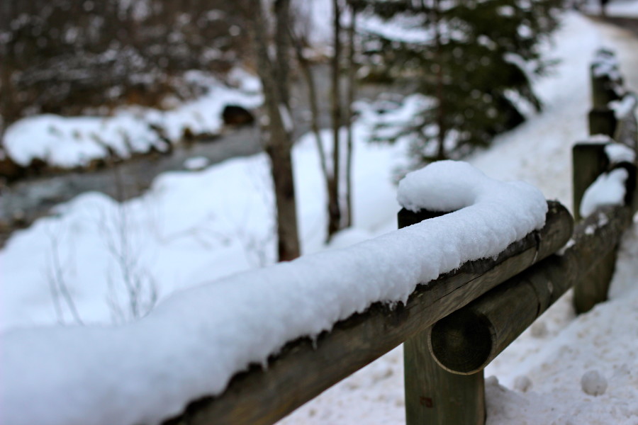 snow on the fence at the river in canazei